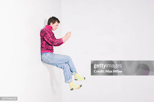caucasian man using cell phone in mid - sitting and using smartphone studio stock-fotos und bilder