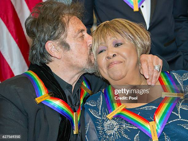 Al Pacino one of the five recipients of the 39th Annual Kennedy Center Honors kisses another recipient, gospel and blues singer Mavis Staples as they...