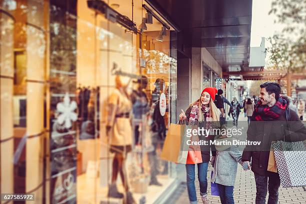 young family shopping for christmas - christmas gift bag stock pictures, royalty-free photos & images