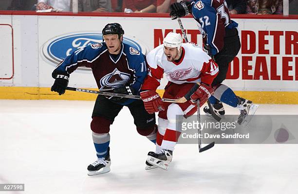 Defenseman Darius Kasparaitis of the Colorado Avalanche slashes defenseman Mathieu Dandenault of the Detroit Red Wings during game five of the...