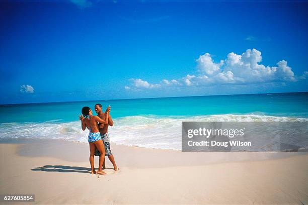 couple holding each other on a beach - bermuda people stock pictures, royalty-free photos & images