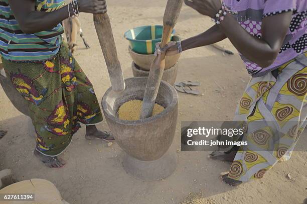 the women crush the corn - african mortar and pestle stock pictures, royalty-free photos & images