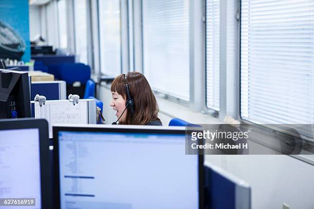 businesswoman talking on telephone in office - コールセンター　日本 ストックフォトと画像
