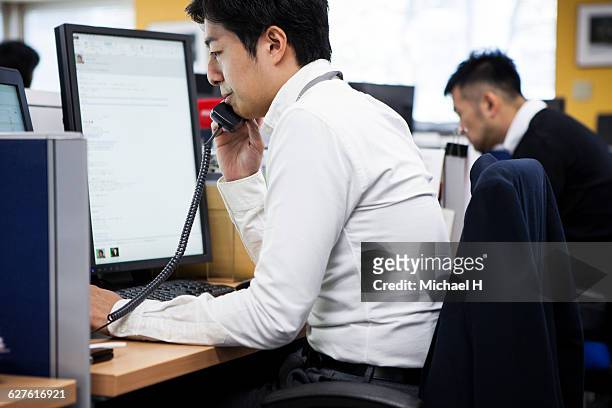businessman talking on telephone in office - コールセンター　日本 ストックフォトと画像