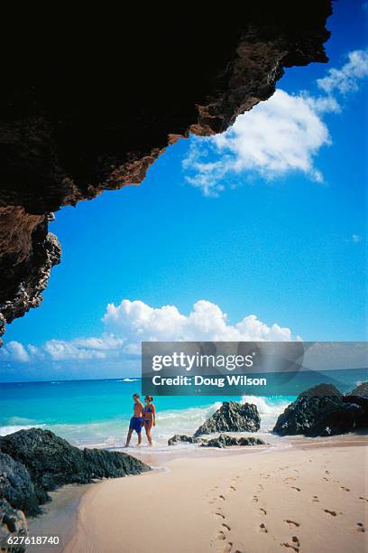 couple walking along the beach - bermuda beach stockfoto's en -beelden