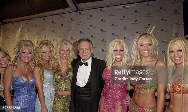 Hugh Hefner and his girlfriends arrive at the Warner Brothers Grammy party.