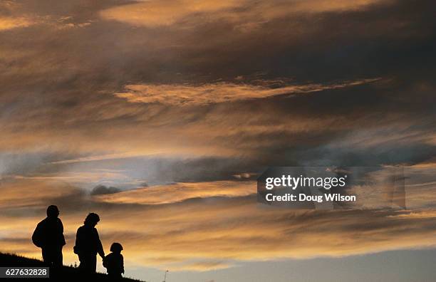 family walking at sunset - three people silhouette stock pictures, royalty-free photos & images