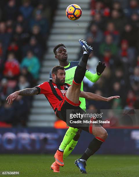 Adam Smith of AFC Bournemouth clears from Divock Origi of Liverpool during the Premier League match between AFC Bournemouth and Liverpool at Vitality...