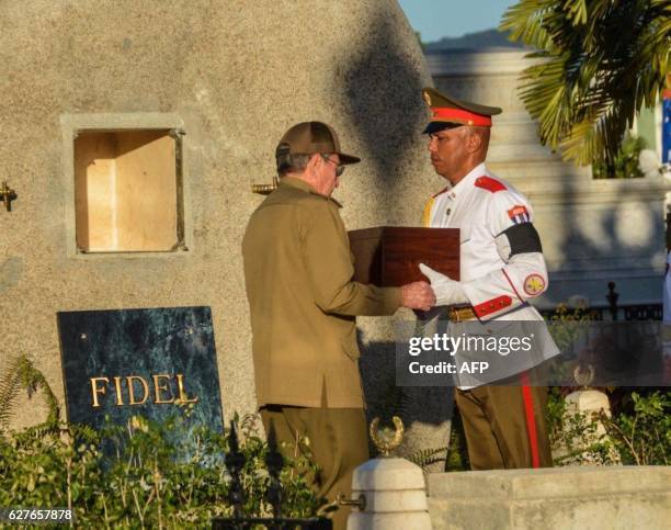 Cuban President Raul Castro places the urn with the ashes of his brother Fidel Castro in his tomb at the Santa Ifigenia cemetery in Santiago de Cuba...