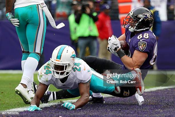 Tight end Dennis Pitta of the Baltimore Ravens scores a first quarter touchdown against strong safety Isa Abdul-Quddus and free safety Bacarri Rambo...