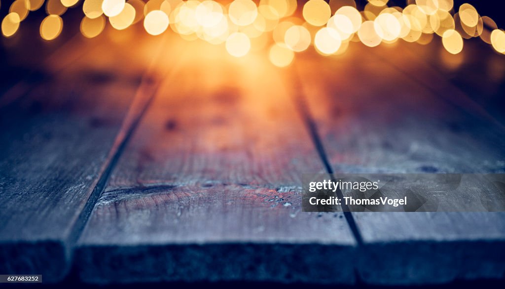 空のテーブルのクリスマスライト - 背景焦点が下がった青い木