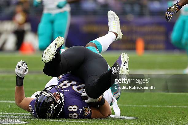 Tight end Dennis Pitta of the Baltimore Ravens is tackled by free safety Bacarri Rambo of the Miami Dolphins in the first quarter at M&T Bank Stadium...