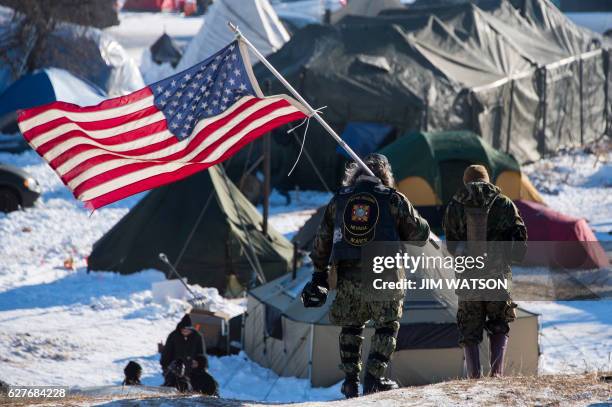 Navy deep sea diving veteran Rob McHaney holds an American flag as he leads a group of veteran activists back from a police barricade on a bridge...