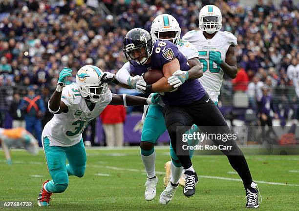Tight end Dennis Pitta of the Baltimore Ravens scores a second quarter touchdown against free safety Michael Thomas, free safety Bacarri Rambo and...
