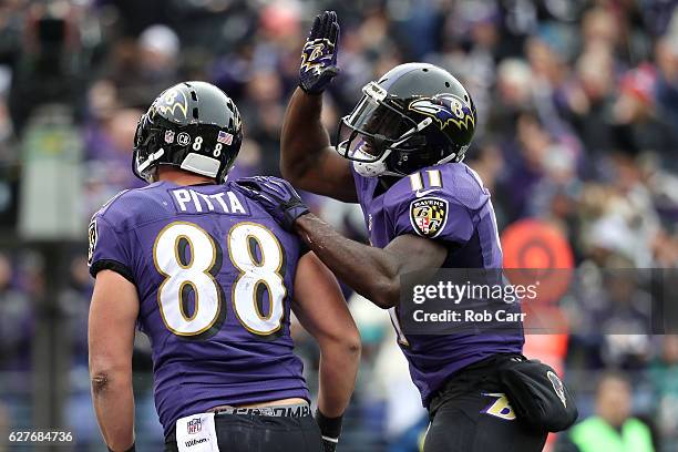 Tight end Dennis Pitta of the Baltimore Ravens celebrates with teammate wide receiver Kamar Aiken after scoring a second quarter touchdown against...