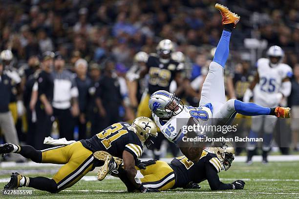 Eric Ebron of the Detroit Lions is tackled by Jairus Byrd of the New Orleans Saints and Kenny Vaccaro during the first half of a game at the...