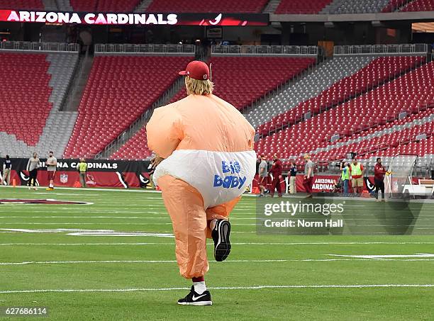 Zac Dysert of the Arizona Cardinals stretches while wearing an inflatable baby costume prior to a game against the Washington Redskins at University...