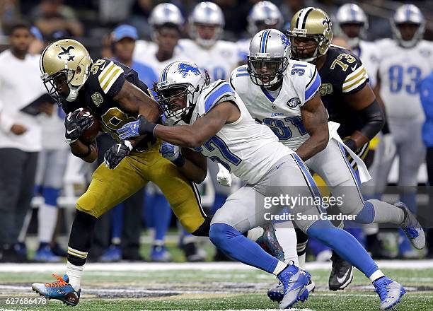 Daniel Lasco of the New Orleans Saints is tackled by Josh Bynes of the Detroit Lions during the first half during a game at the Mercedes-Benz...