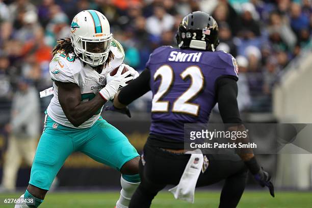 Running back Jay Ajayi of the Miami Dolphins carries the ball against cornerback Jimmy Smith of the Baltimore Ravens in the second quarter at M&T...