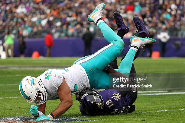Wide receiver Breshad Perriman of the Baltimore Ravens is tackled by linebacker Spencer Paysinger of the Miami Dolphins in the second quarter at M&T...