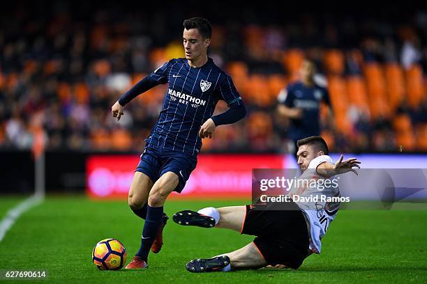 Juanpi Anor of Malaga CF competes for the ball with Guilherme Siqueira of Valencia CF during the La Liga match between Valencia CF and Malaga CF at...