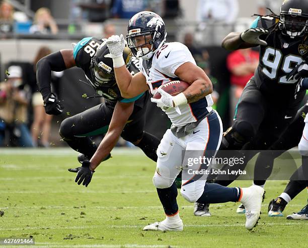 Denver Broncos running back Devontae Booker escapes a tackle by Jacksonville Jaguars linebacker Arthur Brown during the first quarter December 4,...