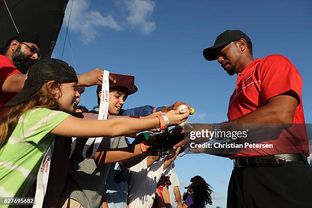 Tiger Woods of the United States signs autographs for young fans following the final round of the Hero World Challenge at Albany, The Bahamas on...