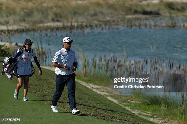 Hideki Matsuyama walks to the 12th green with caddie Mei Inui during the final round of the Hero World Challenge at Albany, The Bahamas on December...