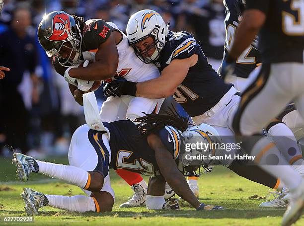 Kyle Emanuel and Jahleel Addae of the San Diego Chargers bring down Jacquizz Rodgers of the Tampa Bay Buccaneers during the first half of a game at...