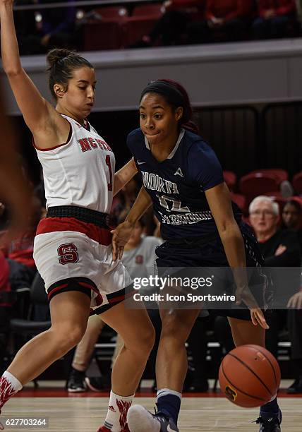 North Florida Ospreys guard Tesh Hanson drives around North Carolina State Wolfpack guard Aislinn Konig during the game between the North Florida...