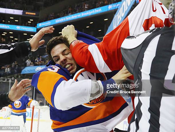 Travis Hamonic of the New York Islanders fights with Steve Ott of the Detroit Red Wings during the first period at the Barclays Center on December 4,...