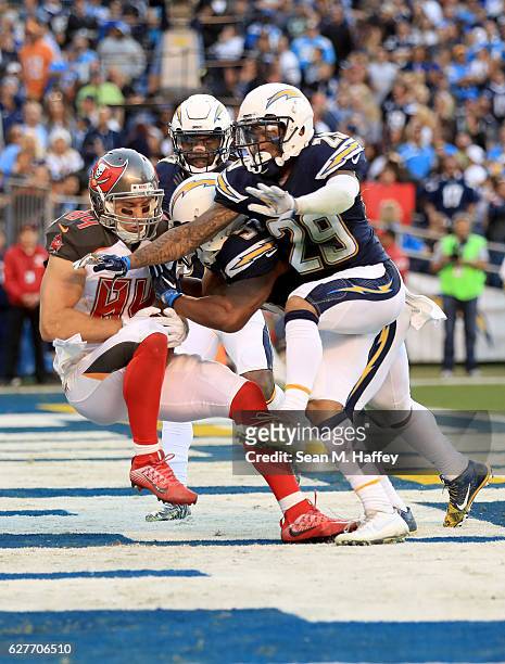 Craig Mager and Jatavis Brown of the San Diego Chargers tackle Cameron Brate of the Tampa Bay Buccaneers as he scores a touchdown on a short pass...