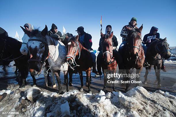 Native American riders listen at an interfaith ceremony at Oceti Sakowin Camp on the edge of the Standing Rock Sioux Reservation on December 4, 2016...