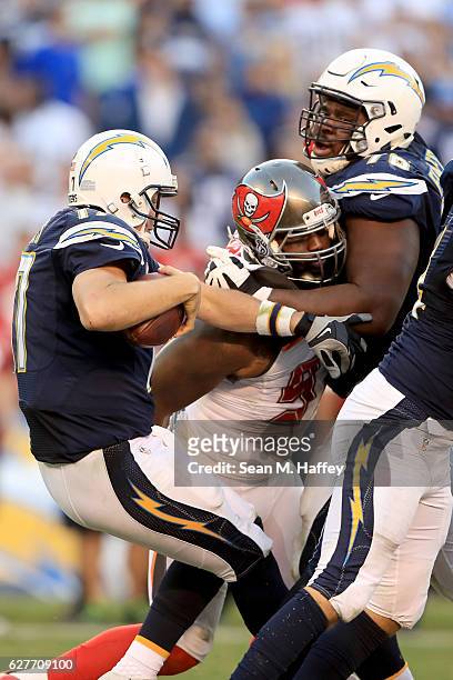 Robert Ayers of the Tampa Bay Buccaneers sacks Philip Rivers as D.J. Fluker of the San Diego Chargers looks on during the second half of a game at...