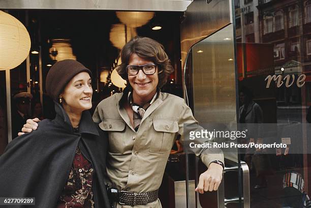 French fashion designer Yves Saint Laurent pictured with the model Loulou de la Falaise in the door way of his new 'Rive Gauche' boutique in Bond...