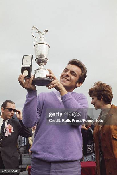 English golfer Tony Jacklin holds up the claret jug Golf Champion trophy and the gold medal after coming first in the final round to win the 1969...