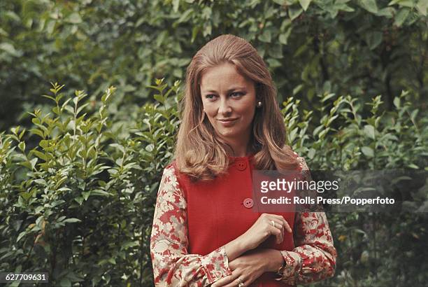 Paola Ruffo di Calabria, later Queen Paola of Belgium, posed wearing a red pinafore dress in a garden in Belgium on 18th June 1969.