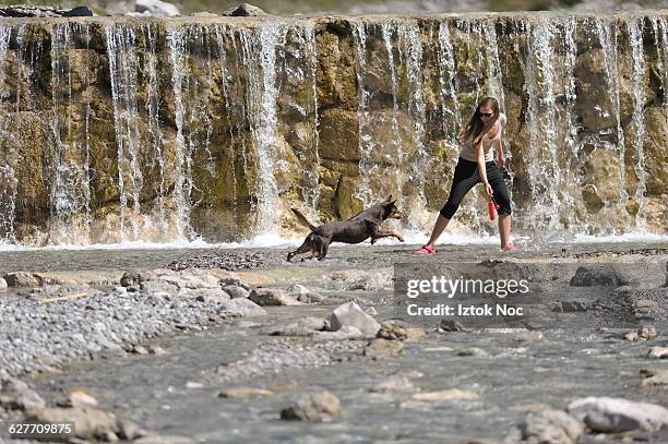 woman and dog play infront of waterfall - イェセニツェ市 ストックフォトと画像