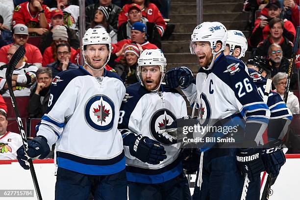 Jacob Trouba , Bryan Little and Blake Wheeler of the Winnipeg Jets react after Little scored against the Chicago Blackhawks in the second period at...