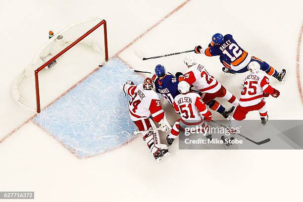 Josh Bailey of the New York Islanders score a third period goal past Petr Mrazek of the Detroit Red Wings as John Tavares looks on at the Barclays...