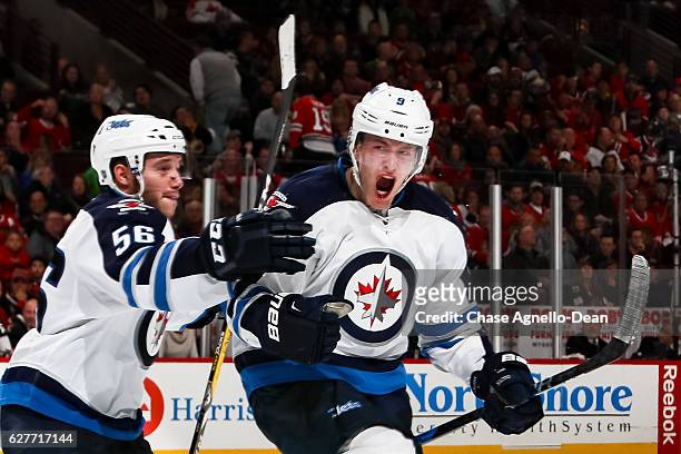 Andrew Copp of the Winnipeg Jets reacts with teammate Marko Dano after scoring the game winning goal against the Chicago Blackhawks in the third...