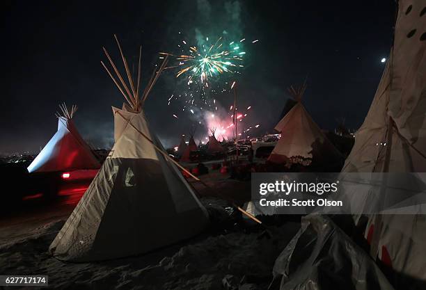 Fireworks fill the night sky above Oceti Sakowin Camp as activists celebrate after learning an easement had been denied for the Dakota Access...