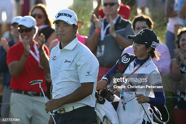 Hideki Matsuyama of Japan and caddie Mei Inui react after chipping onto the 18th green during the final round of the Hero World Challenge at Albany,...