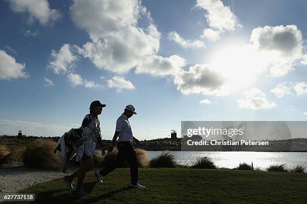 Hideki Matsuyama of Japan and caddie Mei Inui walk down the 17th hole during the final round of the Hero World Challenge at Albany, The Bahamas on...