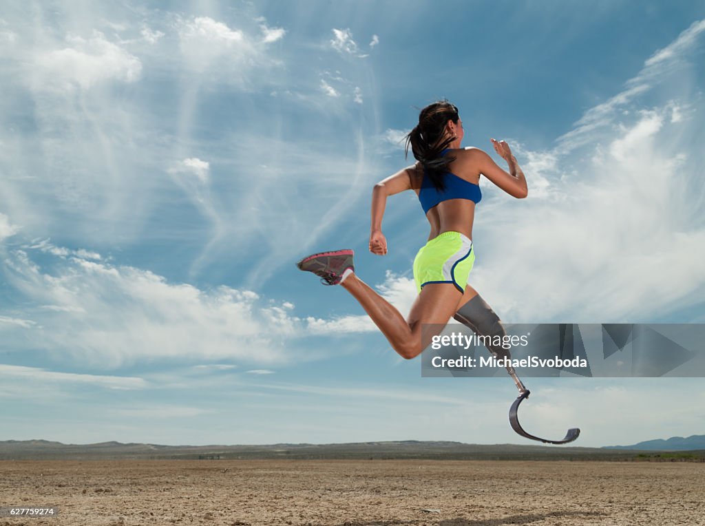 Asian Women With Prosthetic Leg Running In The Desert