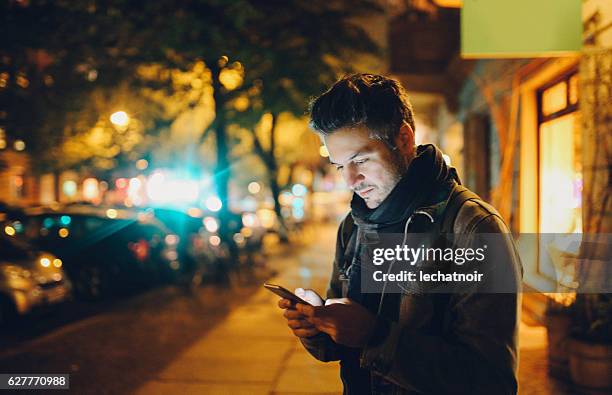 hombre joven que envía mensajes de texto en berlín - un solo hombre fotografías e imágenes de stock
