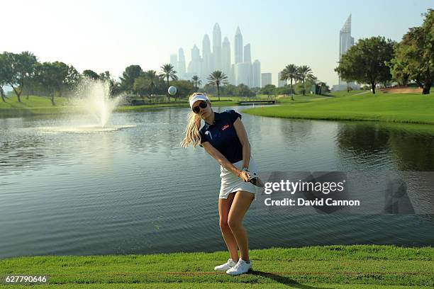 Paige Spiranac of the United States chips to the camera beside the fourth green during her practice round as a preview for the 2016 Omega Dubai...