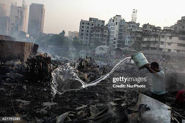 Man try to put water to prevent smoke came out from the fire of the Korail Slum at Dhaka, Bangladesh, 04 December 2016. The flames left over 500...