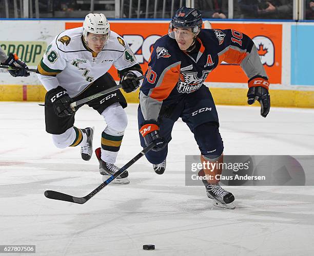 Nicholas Caamano of the Flint Firebirds skates against a checking Sam Miletic of the London Knights during an OHL game at Budweiser Gardens on...