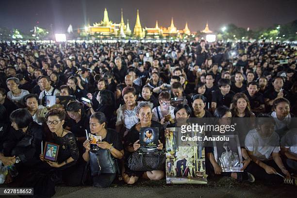 Thais gather in front of the Grand Palace while holding Royal family portraits to pay tribute for the late King Bhumibol Adulyadej on his 89th...